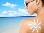 Young Woman With Suntan Lotion On Her Back Stock Photo