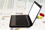 Laptop On Financial Graphs Stock Photo