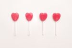 Four Pink Valentine's Day Heart Shape Lollipop Candy Arrange On Empty White Paper Background. Love Concept. Knolling Top View. Minimalism Colorful Hipster Style Stock Photo
