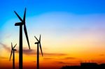 Silhouette Wind Turbine Generator With Factory Emissions Of Carb Stock Photo