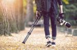 Professional Photographer With Camera And Tripod In Autumn. Vintage Tone Stock Photo