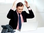 Disappointed Businessman Looking At Laptop Stock Photo