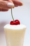 Hand Dips A Cherry In Yogurt Stock Photo