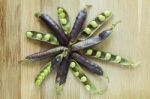 Hybrid Violet Peas In Closeup On A Wooden Background Stock Photo
