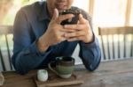 Businessman Using Mobile Phone While Sitting In Coffee Shop Stock Photo
