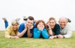 Happy Family Lying On Green Lawn Stock Photo