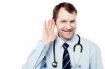 Physician Listening With His Hand On An Ear Stock Photo