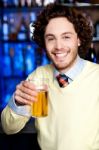 Positive Young Man Holding A Glass Of Beer Stock Photo
