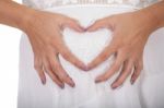Woman Holding Her Hands In A Heart Shape On Her Pregnant Belly Stock Photo
