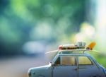 Old Classic Retro Car With Surf Board And Beach  Tool On Roof Against Beautiful Blur Background For Vacation Traveling Theme Stock Photo