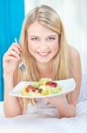 Woman Eating Salad In Bed Stock Photo