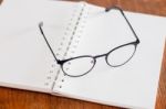 Eyeglasses On Opened Spiral Notebook Stock Photo