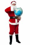 Santa Pointing Out A Continent On Globe Stock Photo
