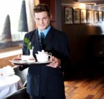 Butler Holding Tea Tray For Guest Stock Photo