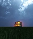 A Single House On Field At Night Stock Photo