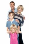 Group Portrait Of A Playful Family Of Four Stock Photo