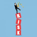 Businessman Carrying His Money On Shaky Risk Blocks Stock Photo
