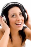 Front View Of Smiling Female Enjoying Music Against White Background Stock Photo