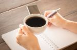 Hand On Coffee Cup And Writing Stock Photo