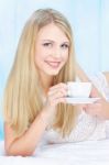 Woman Drinking Coffee In Bed Stock Photo