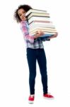 Cute Cheerful Child Carrying Stack Of Books Stock Photo