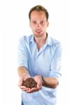 Young Salesman Showing Hands Full With Coffee Beans Stock Photo