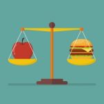 Apple And Hamburger On Scales Stock Photo