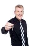 Male Realtor Showing The Keys To Camera Stock Photo