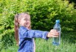 Girl Giving A Plastic Bottle With Water Stock Photo