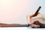 Businessman Hand Holding A Pen Working On Document Stock Photo