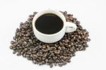 White Cup Of Coffee On Beans Stock Photo