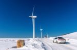 Wind Turbine And Car With Blue Sky In Winter Landscape Stock Photo
