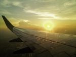 Airplane Wing In The Sky With Sun Setting In Background Stock Photo