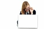 Girl Adjusting Her Spectacles While Working On Laptop Stock Photo