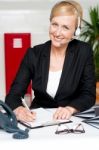 Woman Wearing Headset Writing Stock Photo