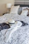 Modern Bedroom With Hat, Sunglass, And Clothes On Blanket Stock Photo