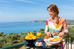 Dutch Woman Eating Breakfast With Sea Background Stock Photo