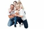 Portrait Of Affectionate Family Of Four In The Studio Stock Photo