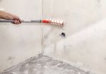 Elderly Worker Painting Wall With Glue Stock Photo