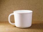 White Plastic Cup On A Wooden Board Stock Photo