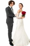 Groom Tucking Brides Dress Stock Photo