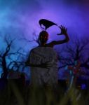 An Undead Holding A Gravestone At Night Surrounding By Black Cats Stock Photo