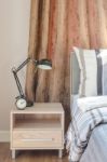 Modern Black Lamp With Black Clock On Wooden Table In Bedroom Stock Photo