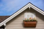 Wooden Window With Flower At The Roof Of The House Stock Photo