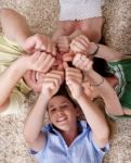 Happy Family Lying  And Showing Thumps Up Together Stock Photo