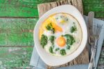 Florentine Eggs With Pureed Spinach On The Wooden Table Top View Stock Photo