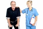 Cheerful Doctor Encouraging Her Patient To Walk With Crutches Stock Photo