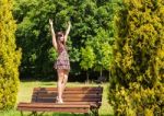Young Beautiful Brunette Standing On A Bench Stock Photo