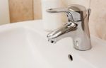 Faucet In A White Sink Stock Photo