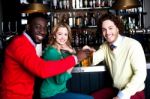 Three Friends In Bar Enjoying Beer Stock Photo